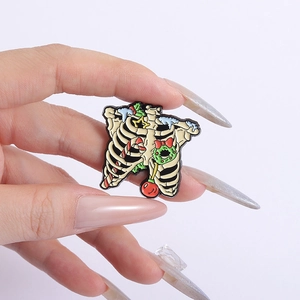 Detailed view of skull rib cage enamel pin with festive Christmas wreath and ornaments