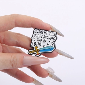 Detailed view of an enamel ADHD side quest pin held by hand to show actual size