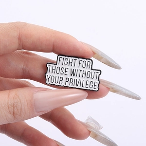 Detail showing 'Fight For Those Without Your Privilege' enamel pin held in hand