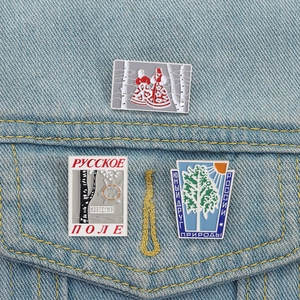 Three Russian folk enamel pins featuring traditional birch tree and ethnic character designs