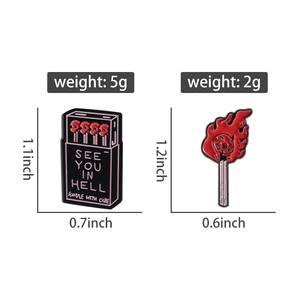 Detail view of gothic enamel pins showing skull matchstick box and burning match