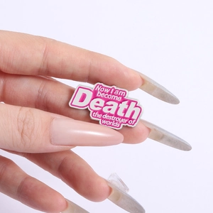 Detail of pink and white enamel pin featuring the famous quote Now I am become Death