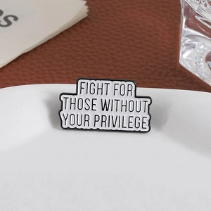 Enamel pin with social justice text Fight For Those Without Your Privilege on white dish