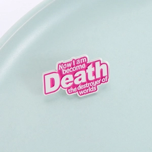 Pink enamel pin featuring 'Now I am become Death' quote on a minimal ceramic tray