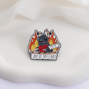 Broche en émail chat noir avec tronçonneuse et texte I Am At My Limit sur fond de feu