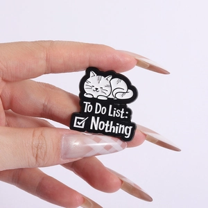 Detail of white cat enamel pin with To Do List: Nothing text in high quality alloy