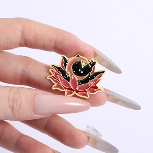 Détail d'une main tenant un badge de lotus céleste avec des éléments de lune et d'étoiles