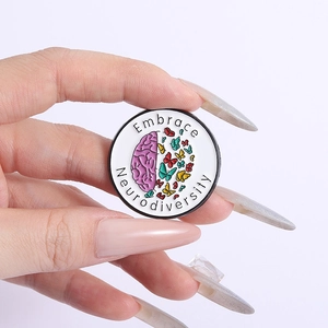 Detail of round enamel pin showing pink brain and colorful butterflies with motto