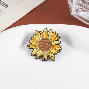 Broche tournesol artistique en émail avec pétales jaunes sur une assiette en porcelaine