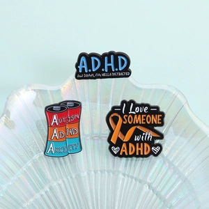 Macro detail of ADHD neurodiversity enamel pins displayed on an iridescent shell tray