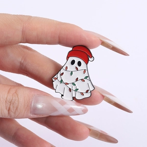 Detail of cute Christmas ghost brooch with red hat and colorful lights held by hand