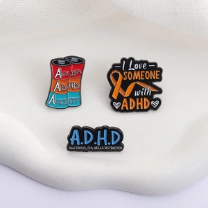 Three-piece ADHD awareness enamel pin set featuring battery and ribbon designs