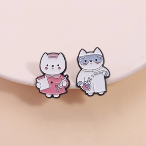 Detail of cartoon nurse and lab scientist cat enamel pins on white ceramic tray