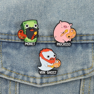 Détail des épinglettes émaillées Monet, Pigcasso et Van Ghost sur tissu denim