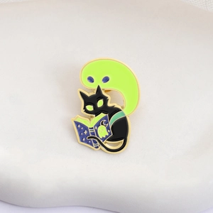 Pin's émaillé lumineux représentant un fantôme et un chat noir lisant un livre