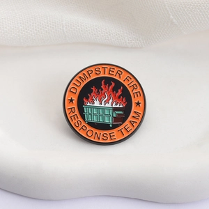 Round metal enamel pin featuring a burning green dumpster fire response team design