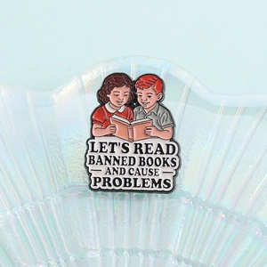 Retro enamel pin showing boy and girl reading books with Let's Read Banned Books slogan