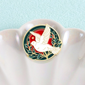 Broche ronde émaillée avec colombe de la paix blanche et branche d'olivier sur fond rouge