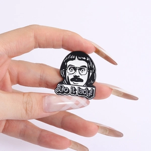 Detailed macro view of black and white enamel pin with comic character and Do it lady text