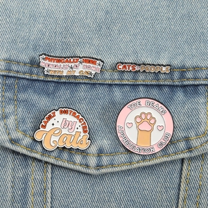 Lot de quatre épingles en émail chat mignon avec texte rigolo sur une veste en jean
