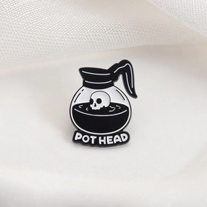 Creative enamel Pot Head brooch featuring a skull in a coffee pot with black liquid