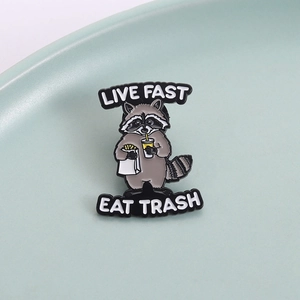 Funny raccoon enamel pin featuring Live Fast Eat Trash text and fast food theme