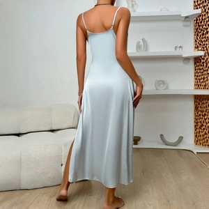 Elegant light blue satin slip dress with open back and side slit in a modern interior