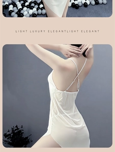 Detail of white silk slip dress featuring elegant cross back straps and side slit hemline