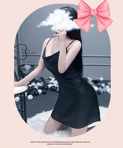 Détail de la nuisette en satin noir avec de fines bretelles et un décolleté en V drapé