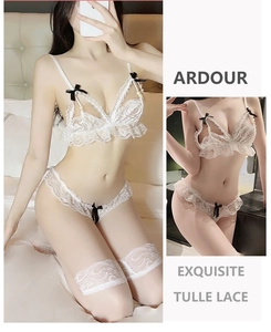 Detailed close-up of white tulle lace lingerie set with black bows and pearl accents
