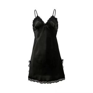 Detail eines schwarzen Satin-Nachthemds mit V-Ausschnitt, Spitze und besticktem Saum