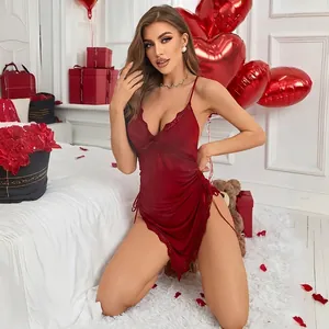 Elegante sottoveste in raso rosso scuro con pizzo e spacco in un ambiente romantico