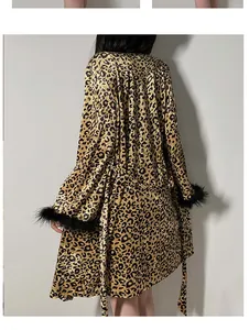 Detail of leopard print velvet robe featuring luxurious black feather trim on sleeves