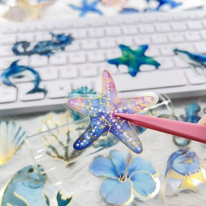 Gold-foiled ocean themed stickers featuring sea creatures like starfish and dolphins