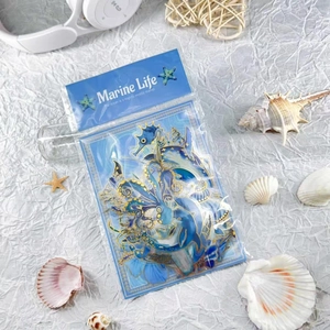 Detail of gold-foiled marine life stickers with seahorse and dolphin designs in packaging