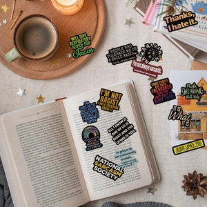 Close-up of funny sarcastic quote stickers on a cozy desktop with coffee and books