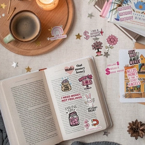 Detail of pink and gold waterproof stickers with money symbols on an open book background