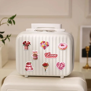 Detail of waterproof Valentine's Day stickers on a white suitcase showing hearts and cakes