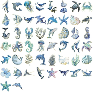 Close-up of gold-stamped ocean stickers featuring watercolor whales and dolphins