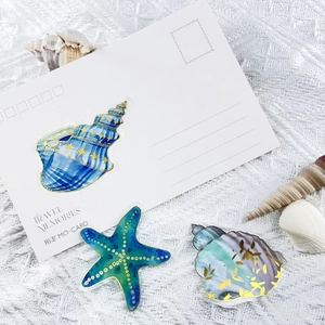 Detail showing gold foil marine animal stickers like sea stars and shells on white background