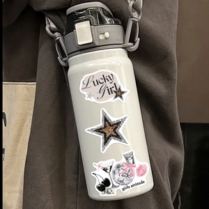 White water bottle with Silver Lucky Girl stickers and grey flip cap on brown backdrop