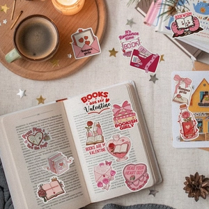 Flat lay of Valentine pink bookish stickers with coffee cup and vintage book background
