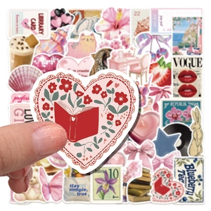 Detail of pink Y2K waterproof stickers held by hand for journal and laptop decor