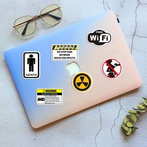 Close-up of waterproof warning stickers on a laptop with diverse creative graphic designs