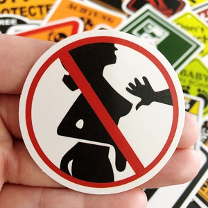 Detailed view of round red and black waterproof warning stickers for luggage and cars