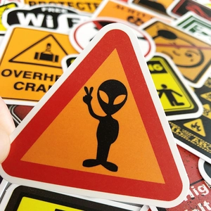 Close-up of assorted waterproof PVC warning stickers including alien and crane signs