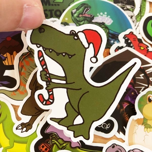 Close-up of waterproof dinosaur sticker featuring a T-Rex with a Christmas hat and candy cane