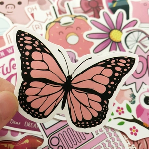Close-up of pink butterfly sticker held by hand among a cute stationery set