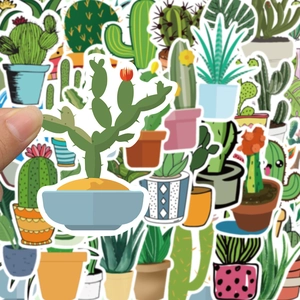 Close-up of hand holding a cartoon cactus sticker with various succulent decals