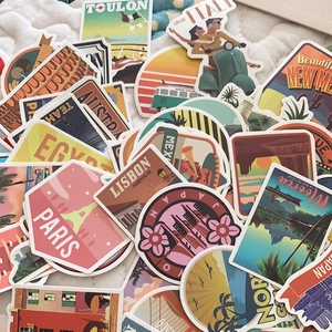Macro detail of assorted vintage world travel stickers on soft white quilted fabric